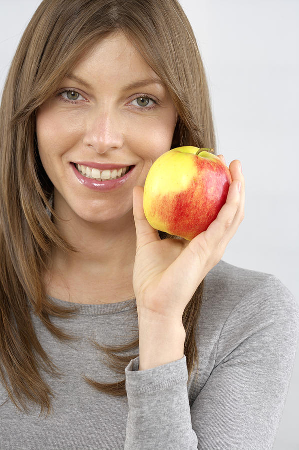 Mid adult woman holding an apple Photograph by Stock4b-rf