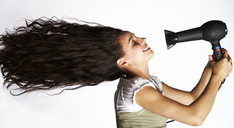 Mid adult woman holding hair dryer in front of face, side view Photograph by Compassionate Eye Foundation/Paul Bradbury/OJO Images Ltd