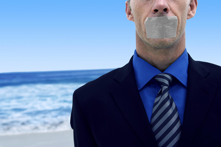 Mid Section View of a Businessman With Duct Tape Covering His Mouth Standing on a Beach by the Ocean Photograph by John Cumming