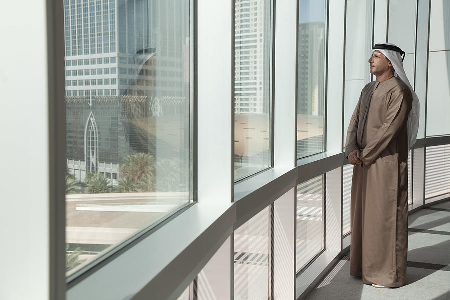 Middle eastern businessman looking out of office window Photograph by Image Source