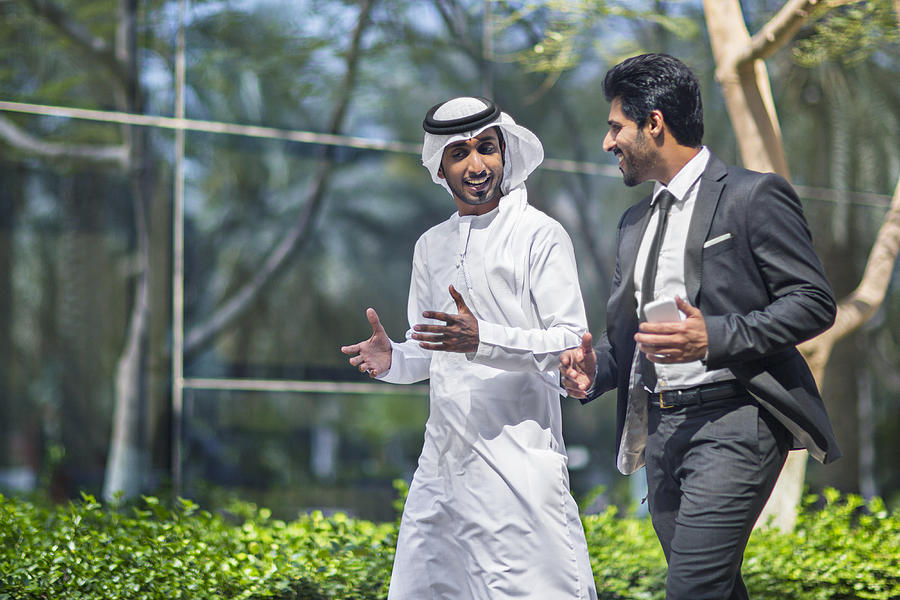 Middle Eastern businessmen talking in the street Photograph by Xavierarnau
