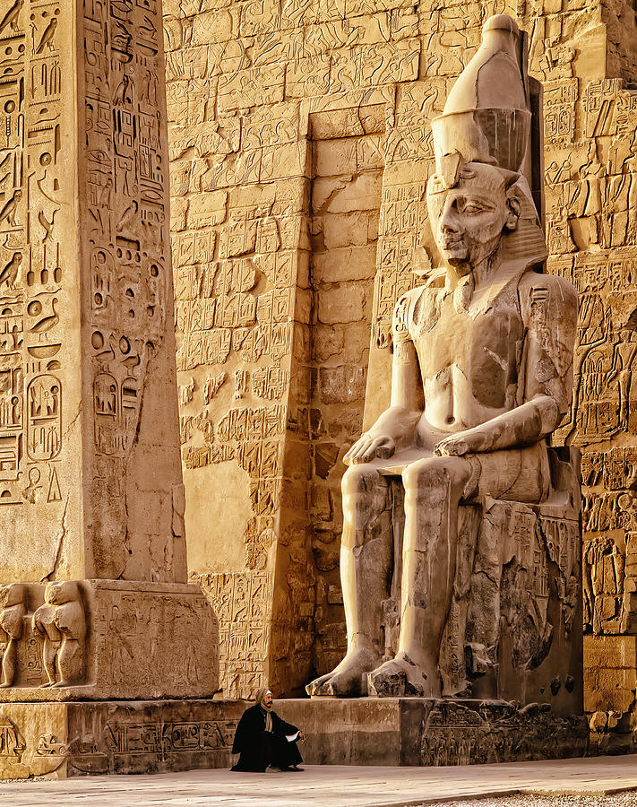 Middle Eastern man under ancient statue, Luxor, Egypt Photograph by Jacobs Stock Photography Ltd