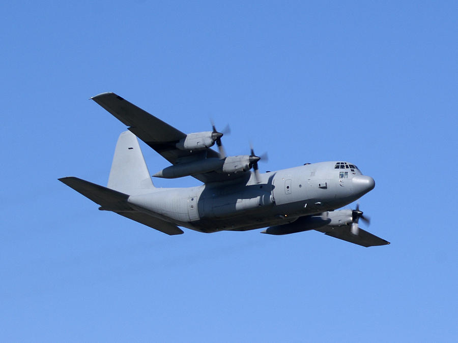military cargo airplane Lockheed C130 Hercules flying in blue sky Photograph by NNehring