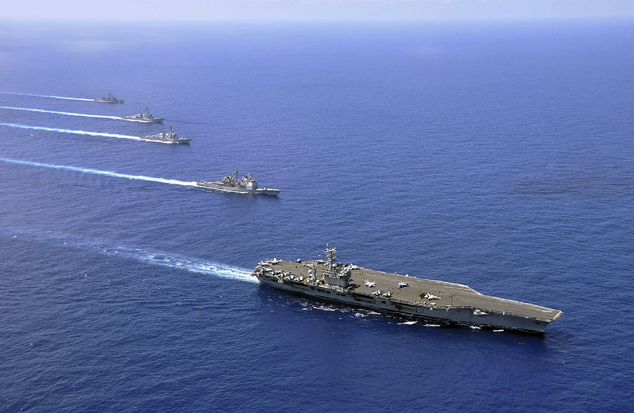Military ships operate in formation in the South China Sea. Photograph by Stocktrek Images
