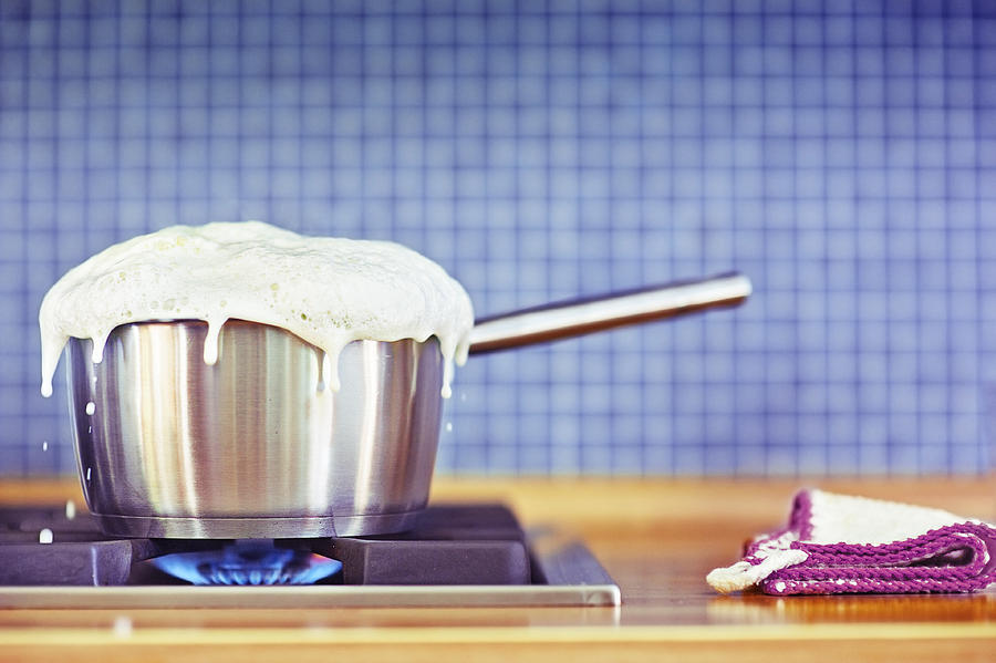 Milk boiling over in pan Photograph by Elisabeth Schmitt