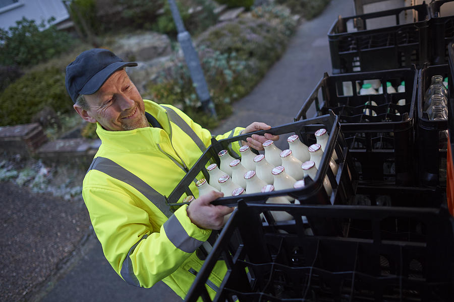 Milkman unloading his milk float in early morning Photograph by Mike Harrington