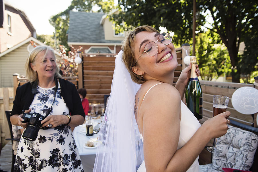 Millennial bride at wedding cocktail in backyard. Photograph by Martinedoucet