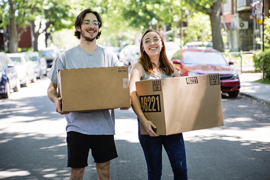 Millennial couple moving in new apartment. Photograph by Martinedoucet