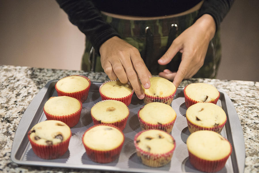 Millennial Hispanic Woman Arranging Baked Cupcakes at Home Orlando USA Photograph by Boogich