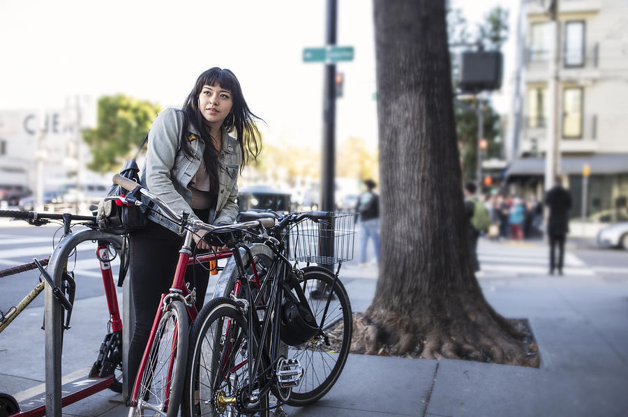 Millennial Latina Bicycle Commuting, Locking Her Bike on City Sidewalk Photograph by Justin Lewis