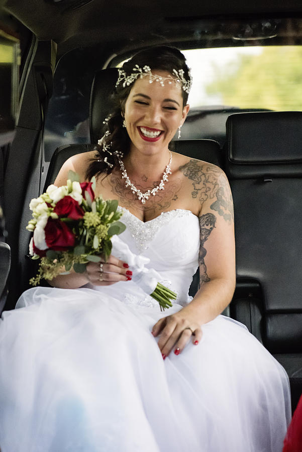 Millennial woman in limousine on her way to wedding. Photograph by Martinedoucet