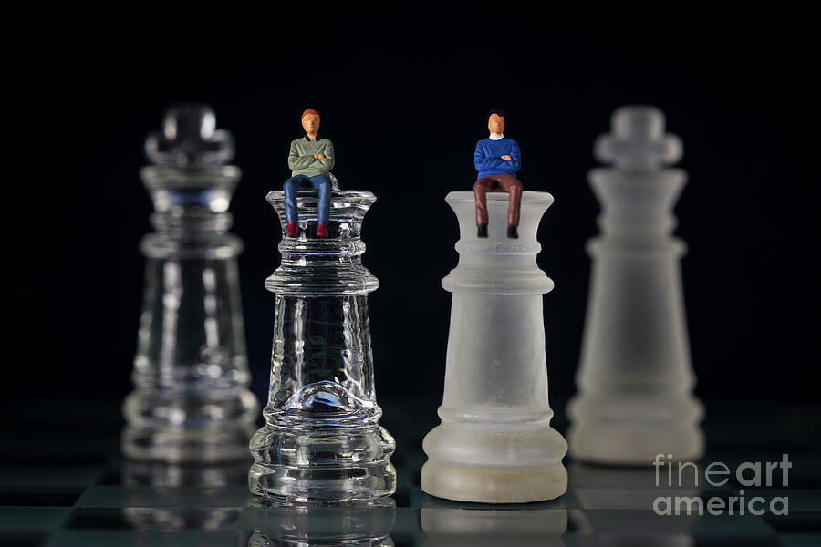 Miniature businessmen 2 people sitting on queen chess piece kings on the back Negotiating in business macro Photograph by Pablo Avanzini