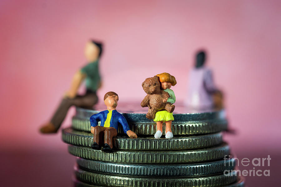 Miniature people. Brother and sister sitting alone. Parents in the background. Concept of family breakup, divorce. Visiting schedule. Macro Photograph by Pablo Avanzini