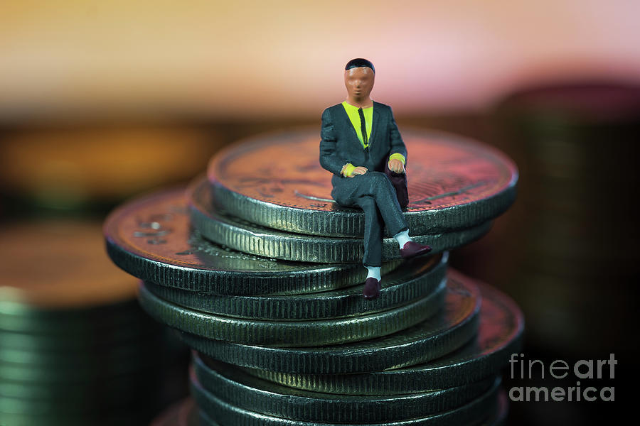 Miniature people Businessman sitting on coin stack warm background. Success Concept. Macro Photograph by Pablo Avanzini