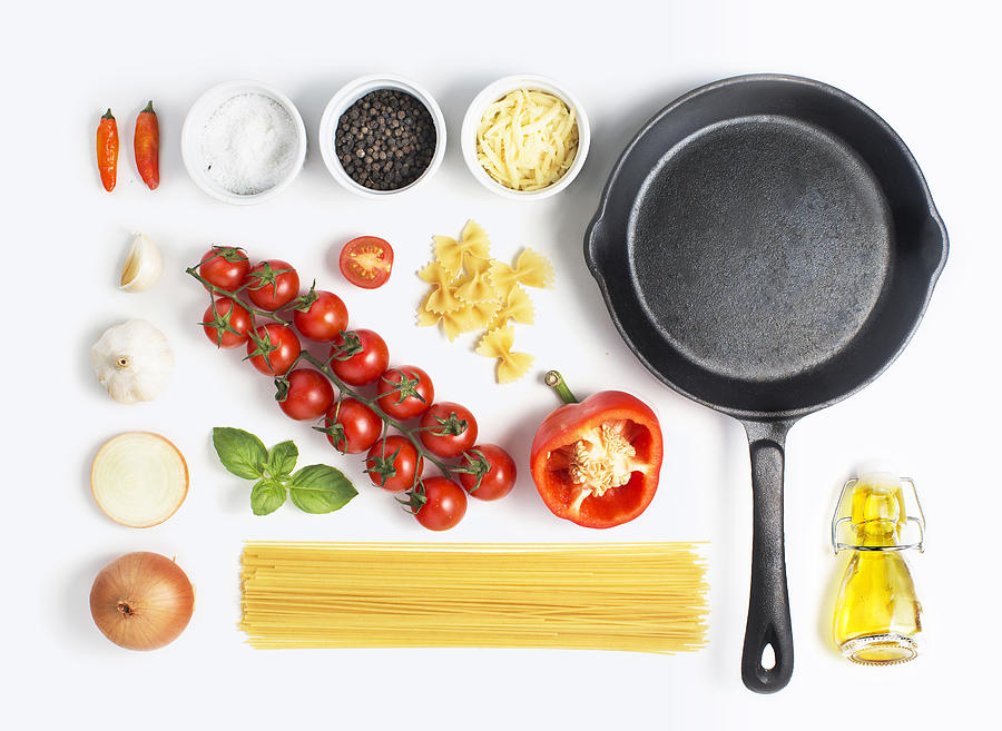 Minimalist style flat lay pasta recipe ingredient and metal cooking pan on white background. Photograph by Twomeows