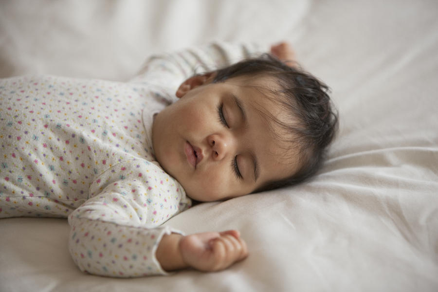 Mixed race baby girl sleeping on bed Photograph by Jose Luis Pelaez Inc