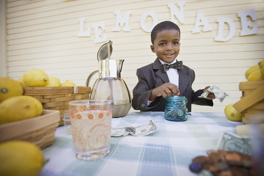 Mixed race boy in suit selling lemonade Photograph by Annika Erickson