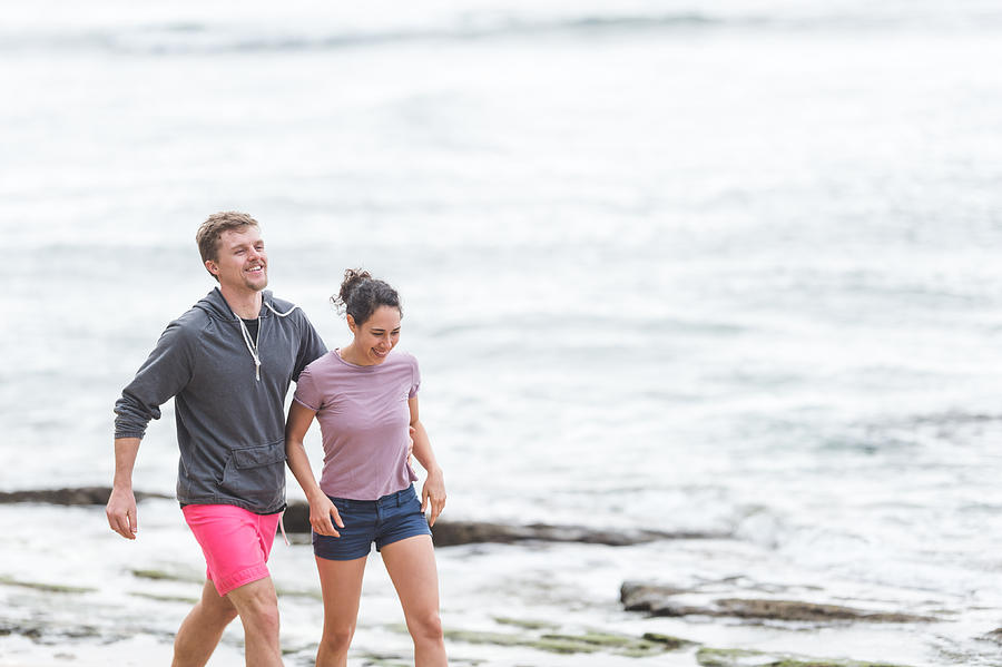 Mixed race couple walk on the Hawaii beach together Photograph by FatCamera