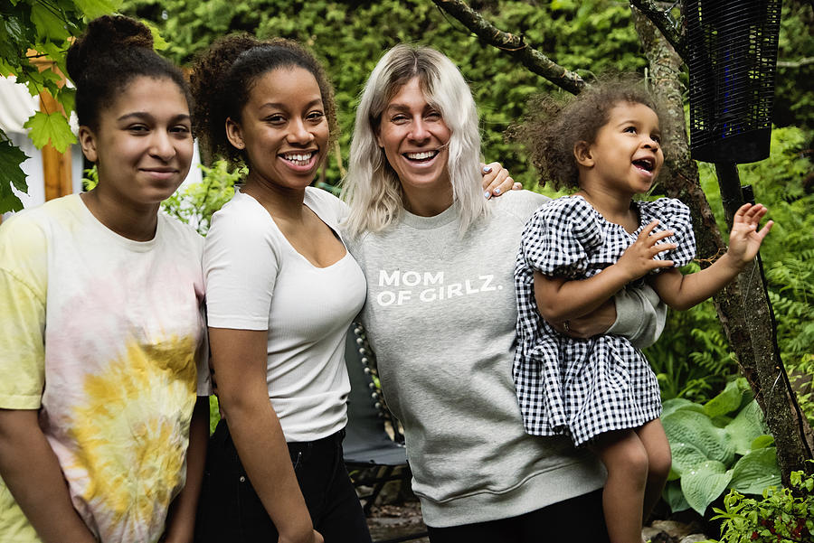 Mixed-race family of girls portrait in backyard. Photograph by Martinedoucet