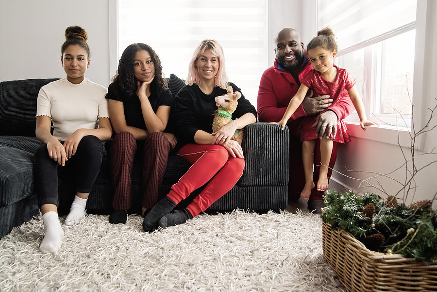 Mixed-race family portrait in living room. Photograph by Martinedoucet