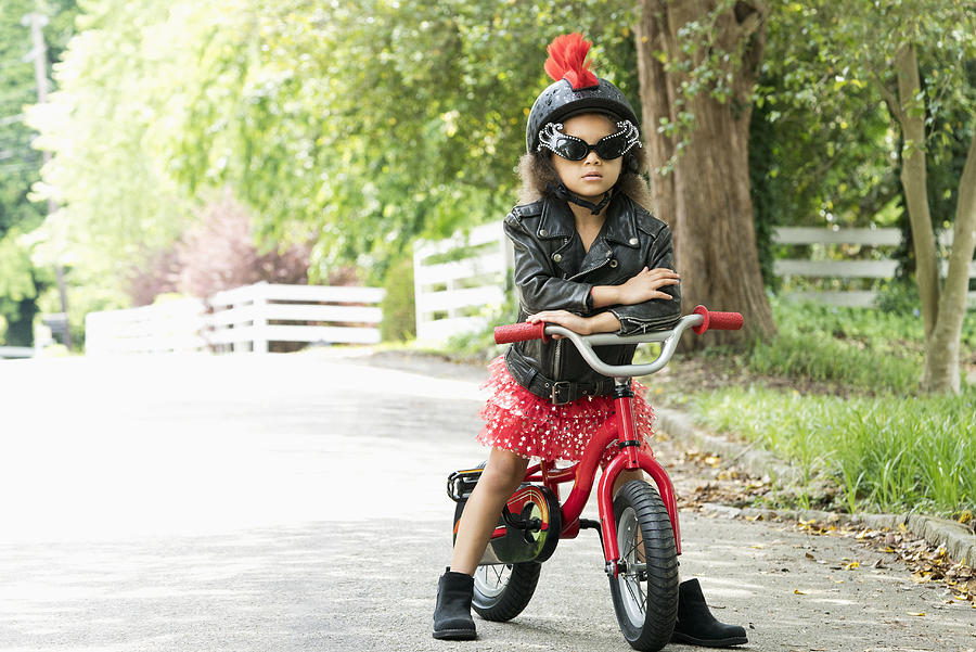Mixed Race girl posing with attitude in leather jacket on bicycle Photograph by Ariel Skelley