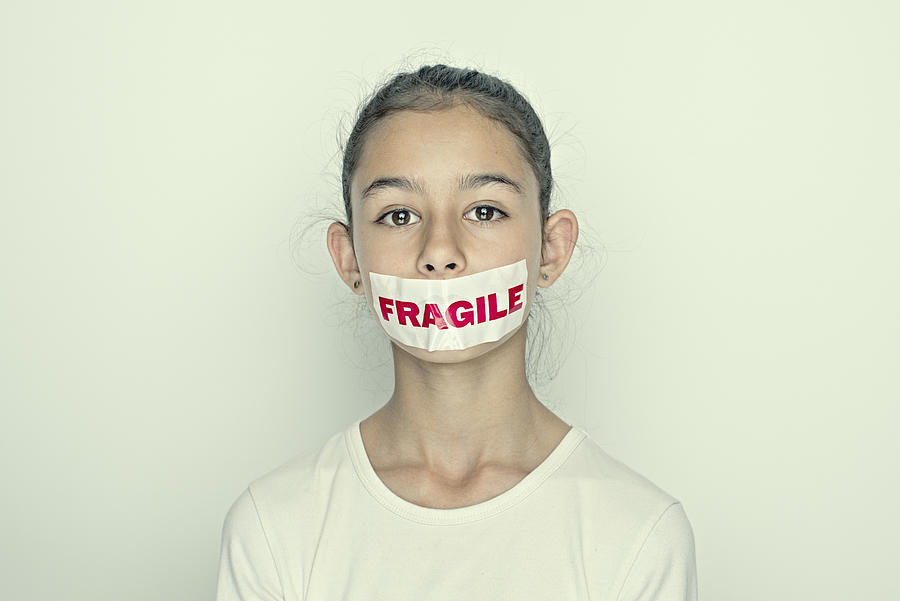 Mixed race girl wearing fragile sticker over mouth Photograph by Donald Iain Smith
