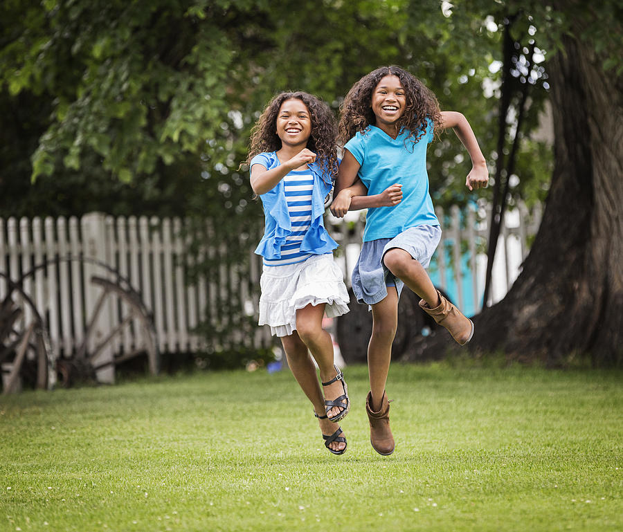 Mixed race girls playing in backyard Photograph by Hill Street Studios