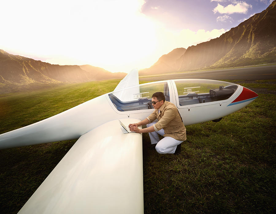 Mixed race man reading map on glider airplane Photograph by Colin Anderson Productions pty ltd