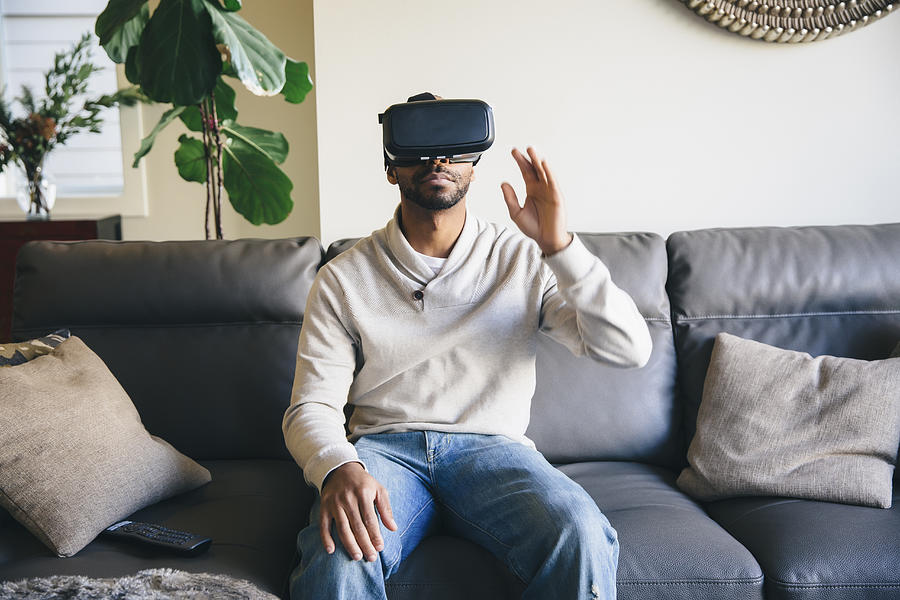 Mixed race man using virtual reality goggles Photograph by Inti St Clair