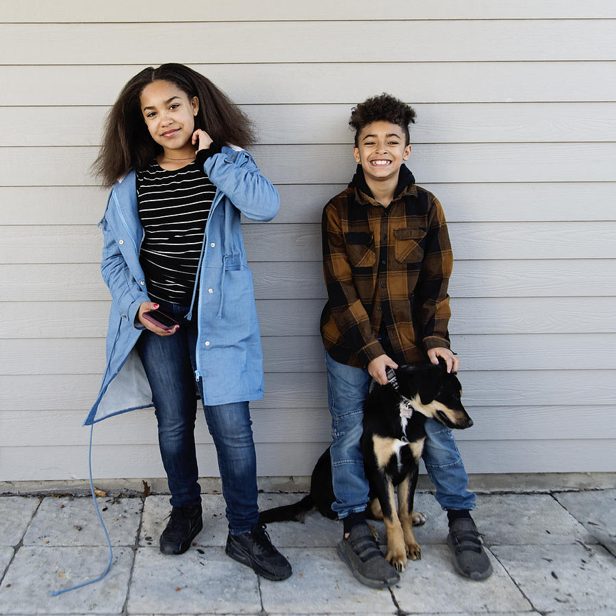 Mixed-race preteen siblings portrait with dog outdoors. Photograph by Martinedoucet