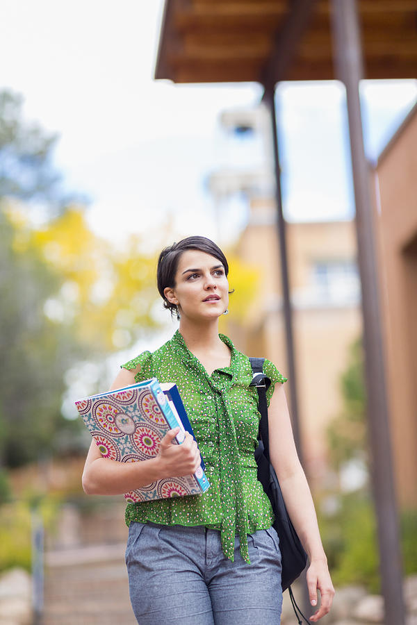 Mixed race student carrying books on campus Photograph by Marc Romanelli