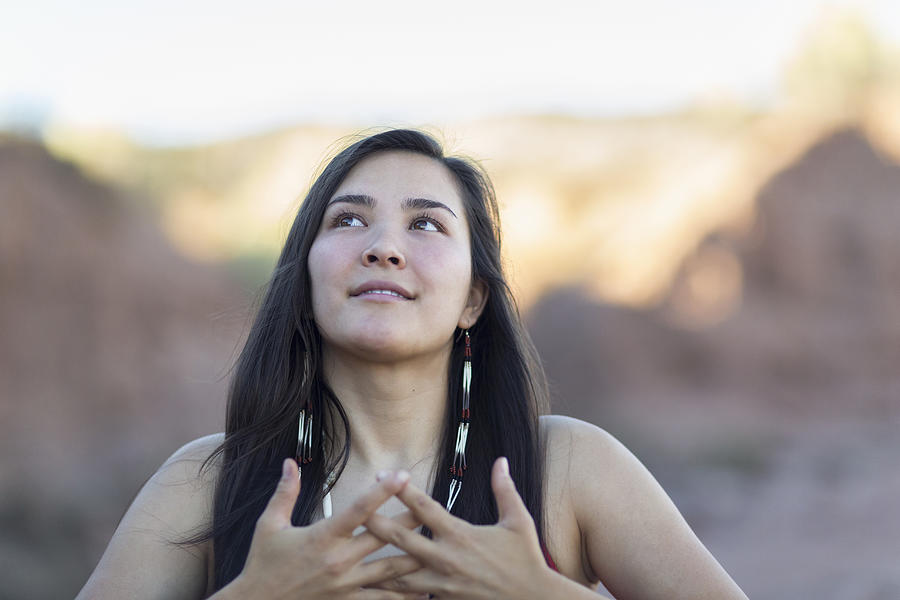 Mixed race woman meditating in desert Photograph by Marc Romanelli