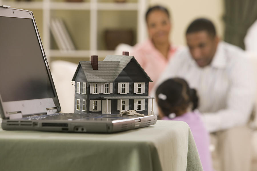 Model house and laptop computer Photograph by Comstock Images
