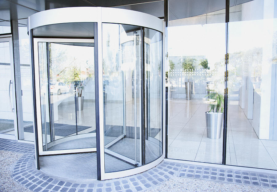 Modern entrance with revolving door Photograph by Martin Barraud