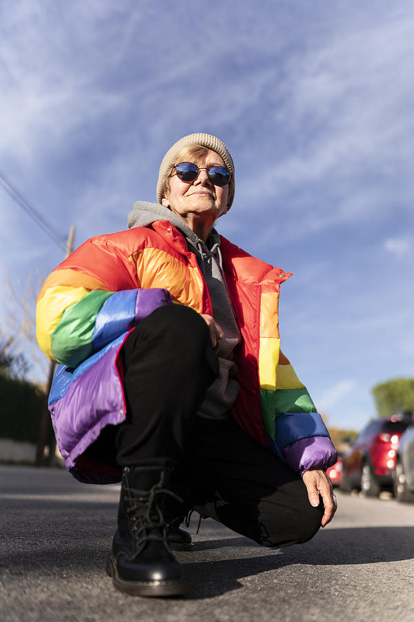 Modern grandmother in rainbow coat posing in the middle of the street. Photograph by Alan Rubio