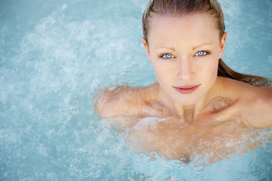 Modern life - Pretty young woman in a hot tub Photograph by GlobalStock