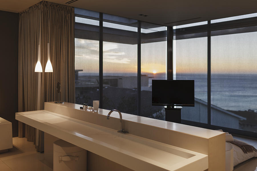 Modern sink in bedroom overlooking ocean at sunset Photograph by Astronaut Images