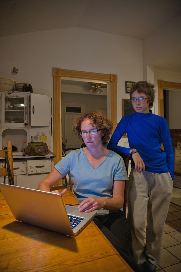 Mom and son with laptop in farm house Photograph by Stephen Simpson