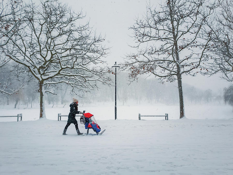 Mom Walks Her Baby In The Snow Photograph