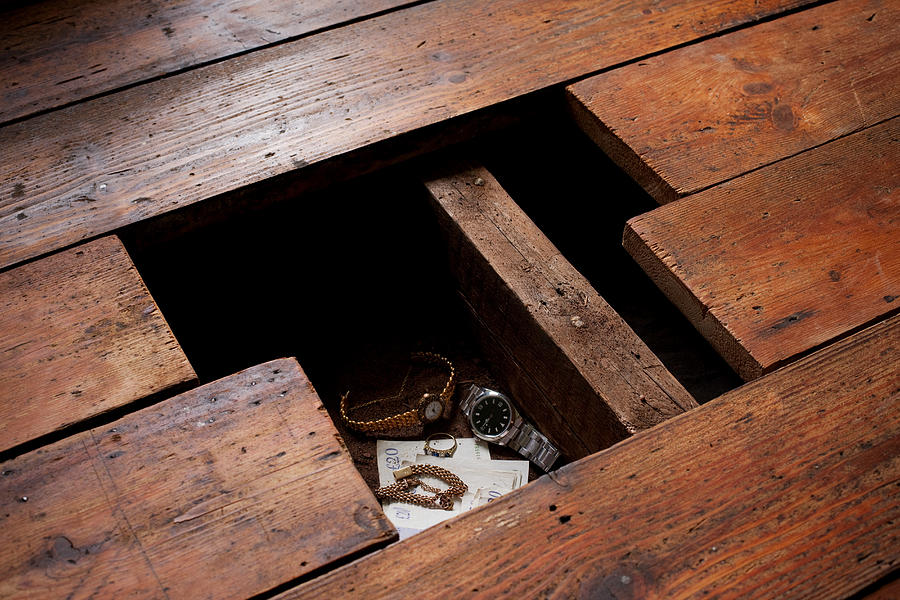 Money and jewellery under floorboards Photograph by Image Source
