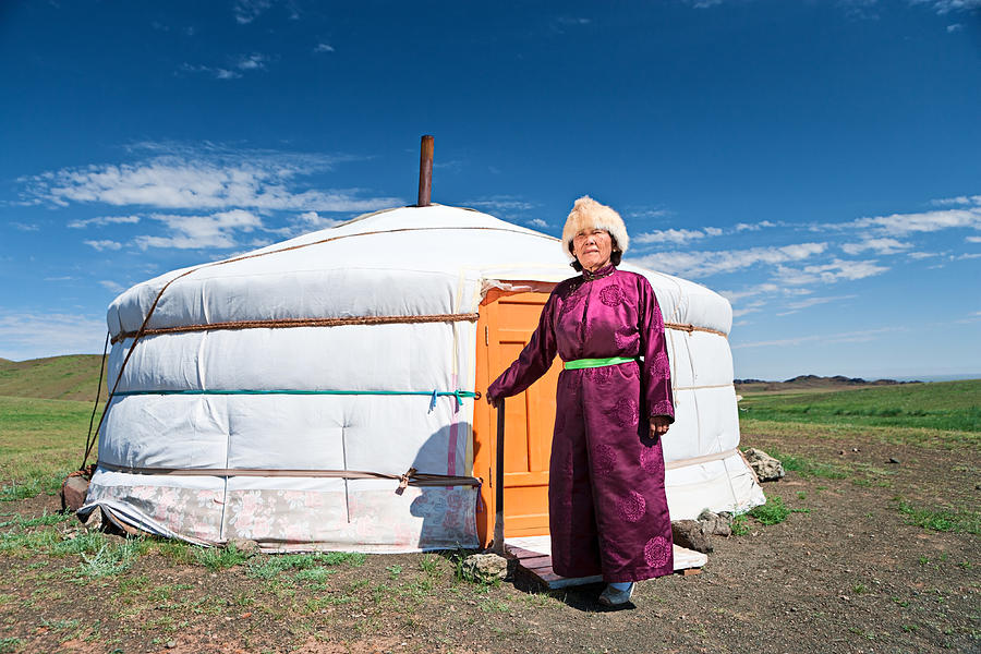 Mongolian woman in national clothing standing next to ger Photograph by Hadynyah