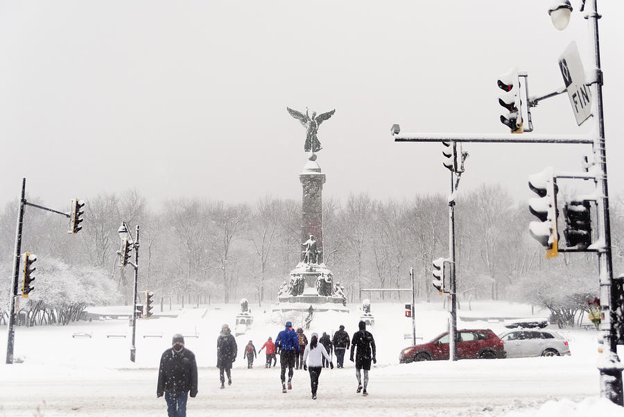 Montreal city park with people enjoying snow storm. Photograph by Martinedoucet