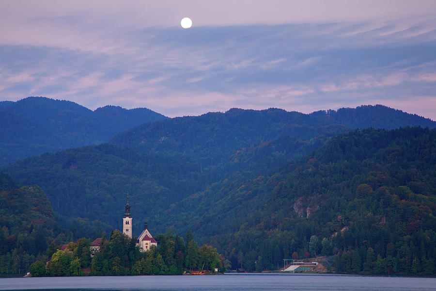 Moon setting at sunrise over Island church at Lake Bled Photograph by Ian Middleton