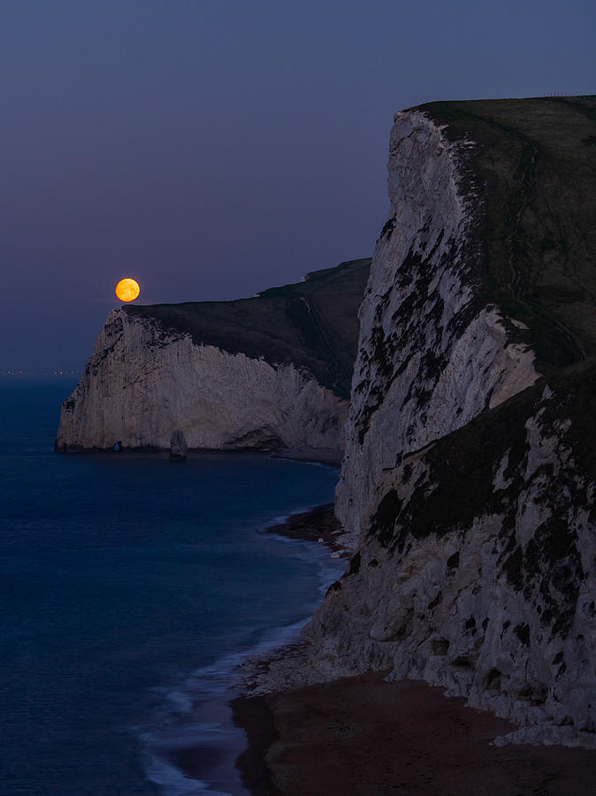 Moonset on Bats Head at Durdle door in England. Photograph by George Afostovremea