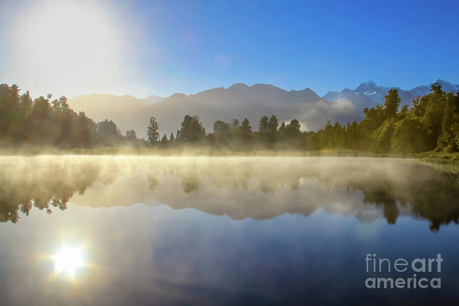Morning haze on Lake Matheson, New Zealand Photograph by Lyl Dil Creations