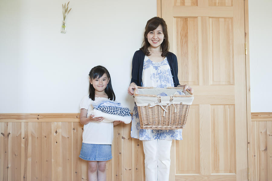 Motehr and daughter holding cloths and basket Photograph by Indeed