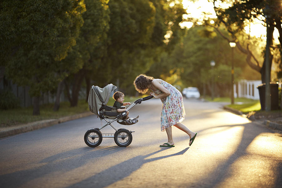 Mother & son walking with stroller in the sunset Photograph by Klaus Vedfelt