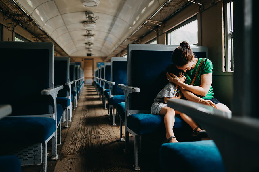 Mother and child having intimate moment in train Photograph by Ippei Naoi
