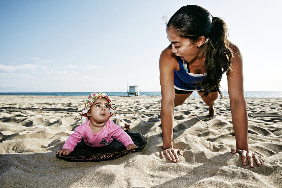 Mother and daughter doing push-ups at beach Photograph by Peathegee Inc