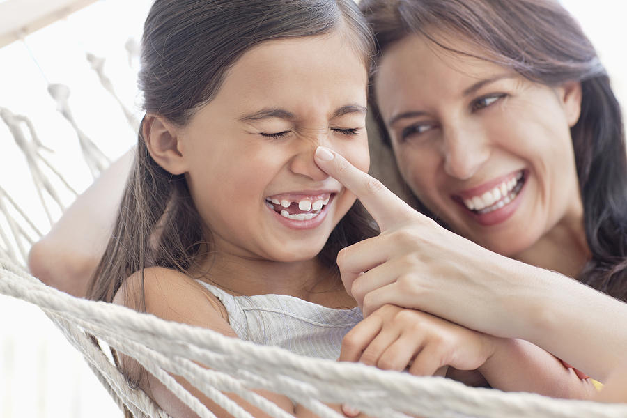 Mother and daughter having fun in hammock Photograph by OJO Images